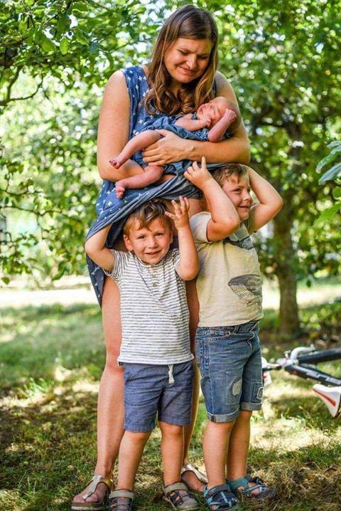 mama-s-ditetem-na-rukou-a-dve-dalsi-se-schovavaji-pod-sukni