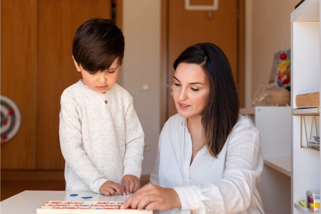 montessori-ucitelka-ukazuje-chlapci-praci-s-pomuckou